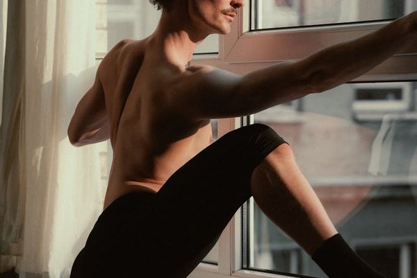 Man performing a powerful warrior yoga pose on a sunny morning.