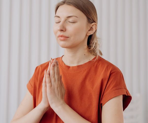 Woman practicing a peaceful yoga pose in a serene setting.
